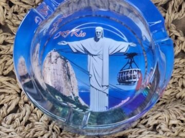 cinzeiro, cristo, céu azul, pão de açucar, arara vermelha, bandeira do brasil.